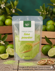 A stand-up pouch of Aussie Rich Freeze Dried lime powder, surrounded by fresh limes, lime slices, dried orange slices, and green leaves on a wooden surface.