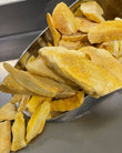 Close-up of freeze-dried mango pieces in a metal scoop.