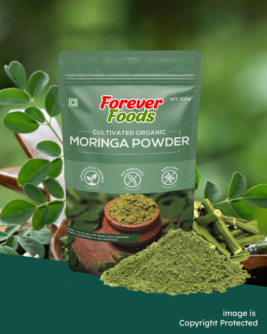 A package of Forever Foods Organic Moringa Powder with a small pile of green powder in front of it, set against a natural background with green foliage.